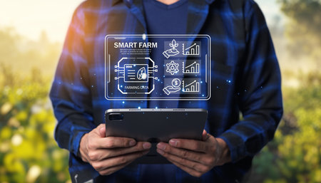 A farmer uses a tablet to monitor data and technology in a modern farm setting. This image reflects the innovation and digitalization in agriculture practices.の写真素材