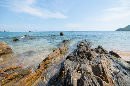 Experience the tranquility of a beautiful shoreline with clear waters and rugged rocks. This scenic view captures the essence of summer and natureの写真素材