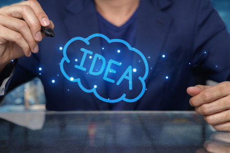 A person illustrates creative thinking with the words "IDEA" in a vibrant cloud. This representation signifies the importance of brainstorming and innovation in business and personal growth.の写真素材