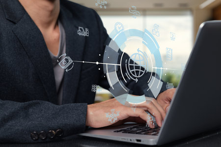 A professional using a laptop symbolizes modern supply chain management. Digital icons represent logistics, communication, and efficiency in business operations.の写真素材