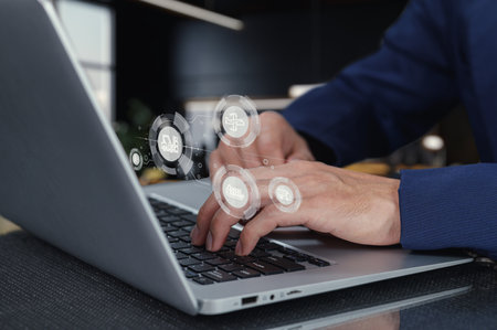 A close-up view of hands typing on a laptop, featuring digital icons representing supply chain concepts. Ideal for technology and business themes.の写真素材