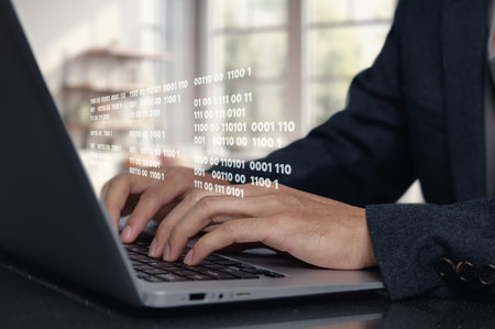 A focused programmer types on a modern laptop, surrounded by binary code. This image captures the essence of technology and coding in a professional workspace.の写真素材