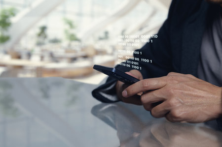 A closeup image of a person using a smartphone with binary code projected from the screen, symbolizing modern technology and digital communication.の写真素材