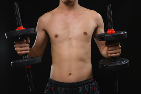 A fit individual showcases strength and health by holding dumbbells, emphasizing commitment to fitness and endurance training for overall well-being.の写真素材