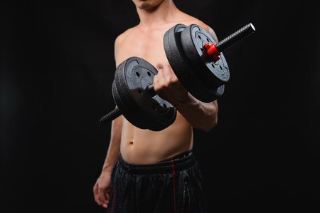 A fitness enthusiast demonstrates strength training using dumbbells, promoting health and wellness through effective workouts. Ideal for gym and exercise themes.の写真素材