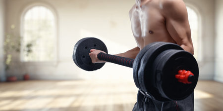 Muscular man exercises with a dumbbell in a modern fitness studio, showcasing strength and determination. Ideal for fitness and health inspiration.の写真素材
