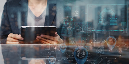 A business professional interacts with a tablet in a modern office, surrounded by digital interfaces and Internet of Things concepts, symbolizing technology and connectivity.の写真素材