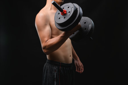 A determined individual lifts a dumbbell, showcasing strength and effort. This image embodies fitness and wellness, focusing on muscle development and physical health.の写真素材