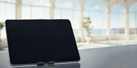 A modern tablet rests on a sleek surface, showcasing the intersection of technology and elegance in a bright, airy space, perfect for inspiration.の写真素材