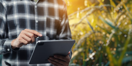 A person engaged with a tablet in a vibrant, natural environment, showcasing a connection between technology and nature. Perfect for themes of lifestyle and innovation.の写真素材