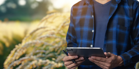 A person stands outdoors, holding a tablet in their hands, surrounded by a beautiful nature scene, showcasing technology and lifestyle in harmony.の写真素材