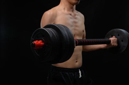 Capture the essence of strength training as an athlete lifts a dumbbell to enhance muscle growth, promote health, and achieve fitness goals in a focused manner.の写真素材