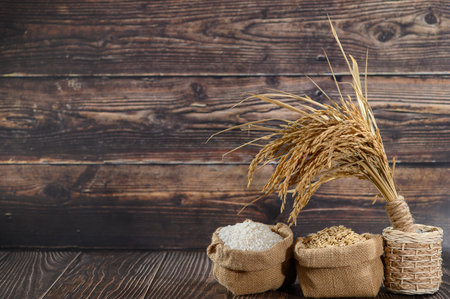 Explore the beauty of natural grains and rice displayed in burlap sacks against a rustic wooden backdrop. Ideal for food photography or agricultural themes.の写真素材