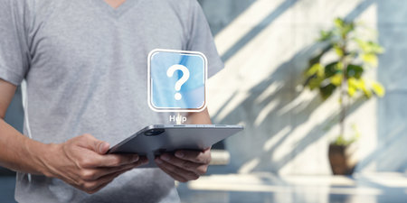 A person holds a tablet displaying a help icon, symbolizing software assistance. This image captures the essence of technology support, aiding users in navigating software programs effectively.の写真素材