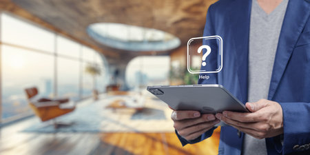 A modern workspace featuring a person holding a tablet displaying a help icon, symbolizing support for software programs. The scene showcases innovation and technology.の写真素材