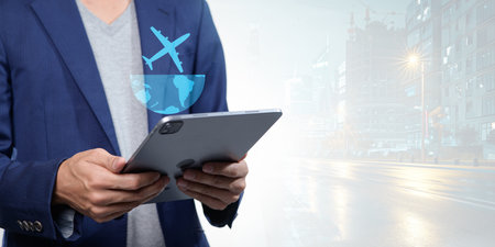 A professional individual engages with a digital device while considering travel for business abroad. The modern city backdrop enhances the theme of connectivity and innovation.の写真素材