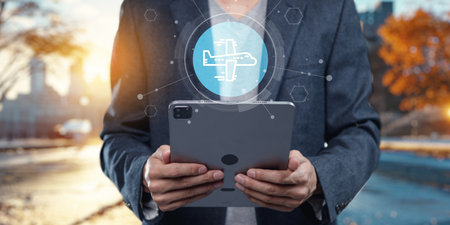 A professional using a tablet outdoors, showcasing modern technology in business travel abroad. The image symbolizes planning and innovation for remote work solutions.の写真素材