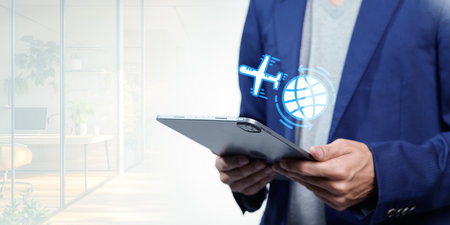 A business professional utilizes a tablet to plan for travel abroad, showcasing the importance of technology in modern international business strategies.の写真素材