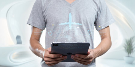 A professional man engages in travel business planning using a tablet, illustrating the blend of technology and modern workspaces in the global travel industry.の写真素材