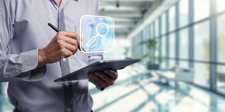 A professional using a tablet to search for information in a modern office setting. The image highlights digital exploration and the importance of technology in research.の写真素材