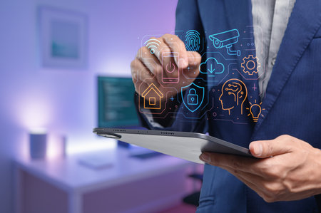 A professional man interacts with a tablet displaying a digital technology interface. The image highlights innovation and connectivity in a modern workspace, showcasing various tech elements.の写真素材