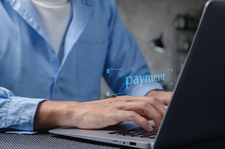 A close-up view of hands typing on a laptop keyboard, suggesting an online payment process in a modern home office setting, showcasing digital finance and business technology.の写真素材