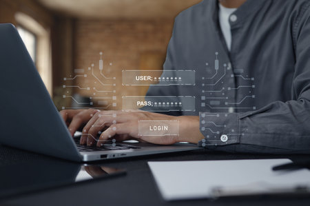 A close-up view of hands typing on a laptop keyboard with a virtual user login interface showcasing username and password fields, set in a modern office.の写真素材