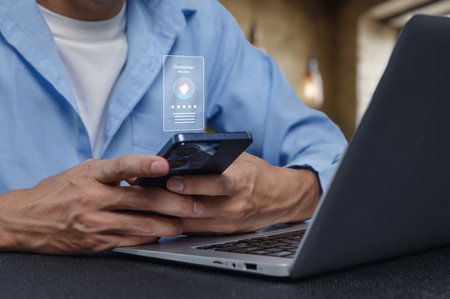A professional individual uses a smartphone and laptop to manage customer interactions, showcasing modern technology in a business environment.の写真素材