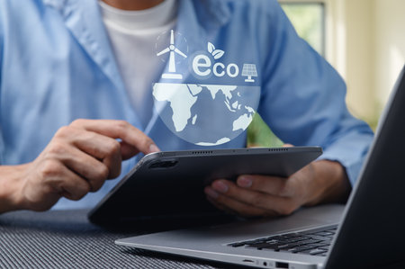 A person interacts with a tablet featuring eco-friendly energy icons, symbolizing a commitment to sustainability and renewable energy innovations for a greener world.の写真素材