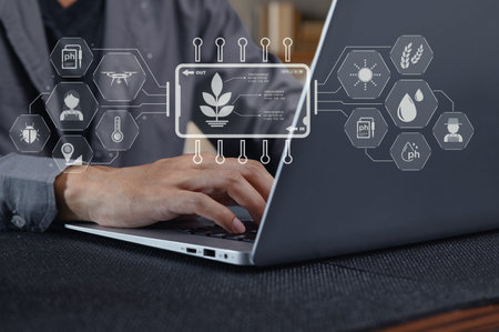A person types on a laptop with digital icons and data analytics representing advanced technology in...