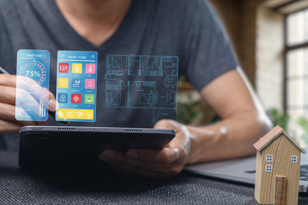 A close-up of a person using a tablet to interact with smart home technology, showcasing icons and digital layout for modern living and home automation.の写真素材