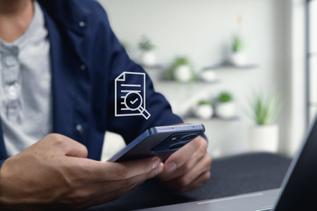 This image captures a person utilizing a smartphone to access digital documents, symbolizing the trend of moving towards paperless solutions for improved efficiency and organization in a modern workspace.の写真素材