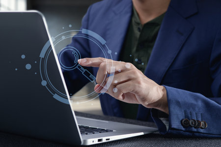 A closeup of a person in a blue blazer interacting with a laptop, featuring a glass magnifying icon. This image highlights online searching and digital engagement in a modern workspace.の写真素材