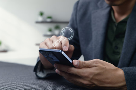 A person interacts with a smartphone, using an online search feature. A glass icon appears on the screen, emphasizing connectivity and modern technology in daily routines.の写真素材