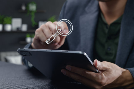 A close-up view of a tablet held by a user displaying a search icon. This modern digital scene represents online information seeking and connectivity.の写真素材