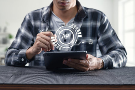 A man engaging with a tablet displays concepts of programming and APIs, showcasing modern interface...