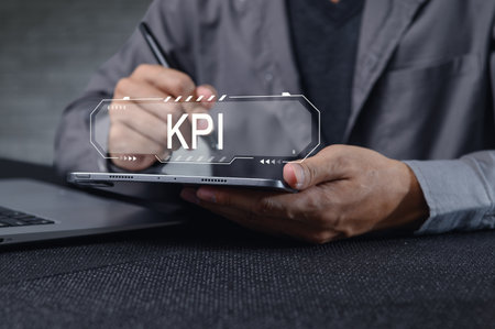 A business professional takes notes on a laptop while analyzing Key Performance Indicators (KPI) in a modern workspace, showcasing strategic evaluation and growth.の写真素材