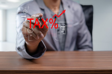 A business professional analyzes tax increases and export impacts, using graphs and data. The image highlights financial strategy and economic growth analysis.の写真素材