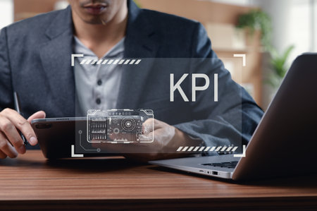 A businessman focuses on analyzing key performance indicators using a tablet and laptop in a modern office. The image captures the essence of data analysis and business strategy.の写真素材