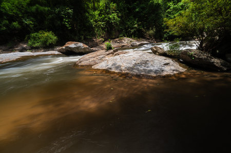 Discover the serene beauty of Mae Klang Waterfall in Chiang Mai, where clear water cascades over rocks, surrounded by lush greenery creating a peaceful escape.の写真素材