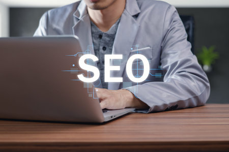 A professional engages with a laptop, focusing on enhancing search engine optimization. The image...