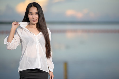 A confident staff member poses in a stylish uniform against a serene nature backdrop, perfect for tourism promotions. The image captures beauty and professionalism.の写真素材