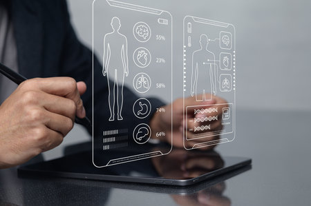 A close-up of hands interacting with a digital tablet displaying anatomical health data. This innovative health care technology showcases real-time patient analytics and insights.の写真素材