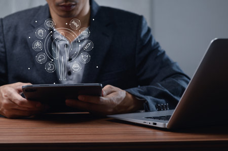 A professional man utilizes a tablet to explore health care management solutions. This image highlights the blend of technology and wellness in modern health practices.の写真素材