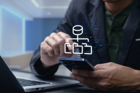 A person interacts with a smartphone displaying a digital network design while working at a modern office, illustrating technology integration and innovation.の写真素材