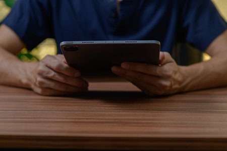 A person engages with a tablet device, showcasing a modern lifestyle. The setting features a sleek...