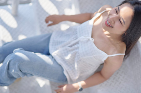 A cheerful woman enjoys her time in a bright, sunlit space, radiating happiness and relaxation. The...