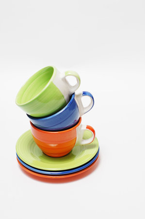 Piled coffee cups with saucers over white background.の写真素材
