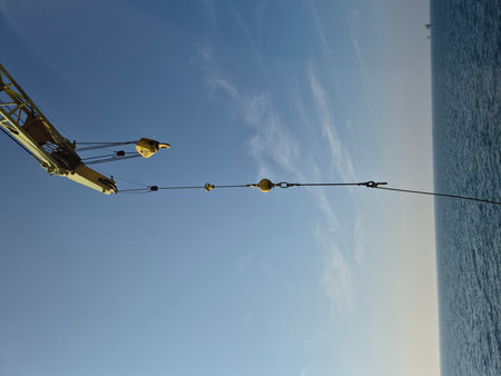 Crane hook and rope against the blue sky. Industrial background.