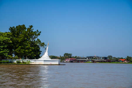 A white pagoda at koh kret near river on blue sky backgroundの写真素材